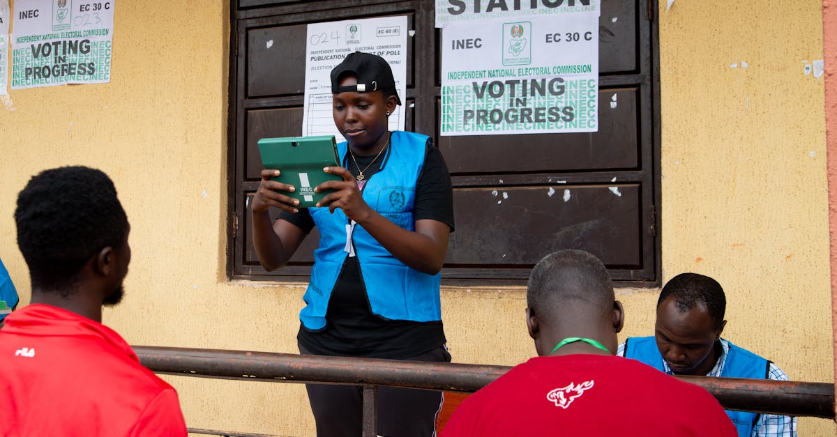 Election official in Nigeria assisting voters on election day at a polling station.